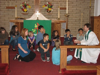 The Pastor gathers the children during worship for the Children's message